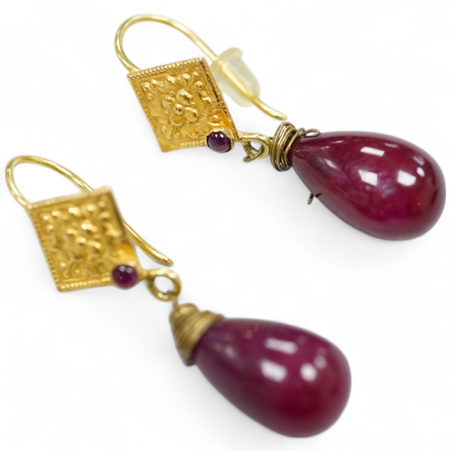 A pair of yellow metal and two stone ruby set teardrop shaped earrings, overall 37mm, gross weight 7.2 grams.